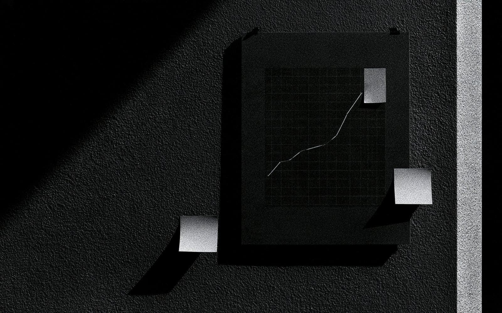 Un graphique de croissance annoté de pastilles sur un mur texturé, photographie éditoriale sombre en noir et blanc au grain tramé avec des ombres marquées.