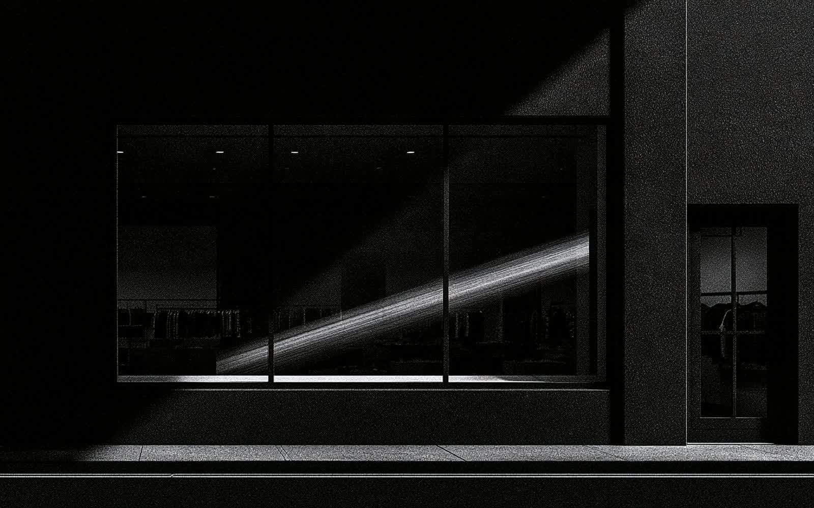 Un câble réseau noir et une lentille photographique posés sur une surface mate, photographie éditoriale sombre en noir et blanc au grain tramé sous une diagonale de lumière.