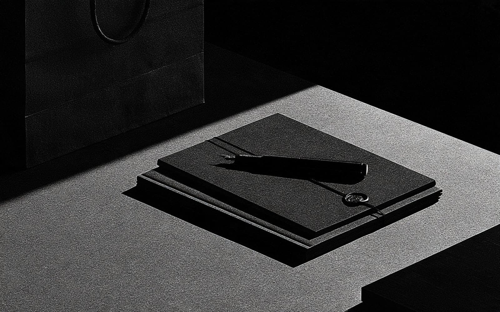Des étiquettes de classification et un peigne de filtrage posés sur un plateau sombre, photographie éditoriale en noir et blanc au grain tramé sous une lumière latérale douce.